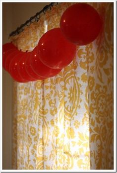 some red balloons hanging from a curtain