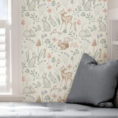 the wall paper has deers and plants on it, along with other decorative items