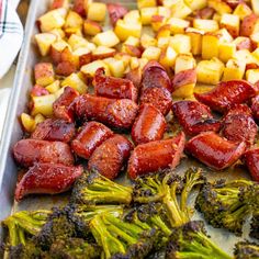 cooked sausages, broccoli and potatoes on a baking sheet