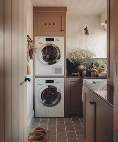 a washer and dryer sitting in a kitchen next to each other on top of a tile floor