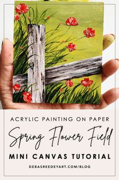 a hand holding a piece of paper with flowers painted on it and the words spring flower field