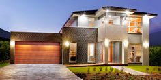 a modern house is lit up at night with lights on the front and side windows