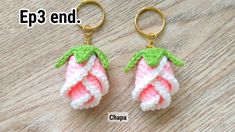 two crocheted strawberry keychains with green leaves and pink flowers on them