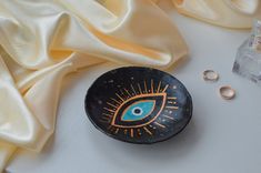 an evil eye painted on a rock next to some rings