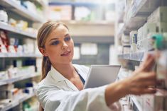 a woman in a pharmacy shop looking at the shelves