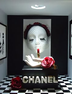 a chanel display with red roses and lipstick