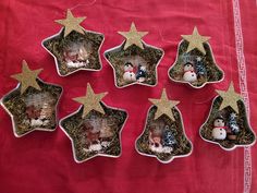 six christmas ornaments are placed in the shape of stars on a red cloth with snowmen