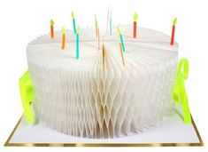 a white cake with yellow and blue candles on it