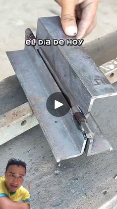 a young boy sitting on the ground next to a piece of metal that has been placed in front of him