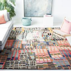 a living room filled with furniture and a rug on top of a white floor next to a couch