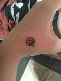 a person's arm with a tattoo on it that has four leaf clovers