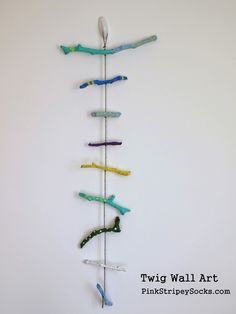 there is a sculpture made out of toothbrushes hanging on the wall with one toothbrush in it's mouth