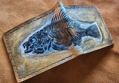 Description Based on a fish fossil, from the Eocene of Wyoming ...roughly 50 million years old.  The wallet is hand carved and textured.  If you would us to make a custom fossil wallet, please contact us and send some pictures.  Thank you Inside Choice: You can choose one of the two options that are shown in the listing pictures for the inside of your the wallet (leave a message to the seller at the checkout to state which option you would prefer) Choose: 1. Photo ID and zipped coin holder and 3x card holders and note sections or 2. 6x card holders and several note sections Dimensions: 9.5cm x 12 cm Fish Fossil, Fossil Wallet, 50 Million, Coin Holder, Leather Bifold Wallet, Intellectual Property, Gift Wrapping Services, Money Clip Wallet, Bifold Wallet