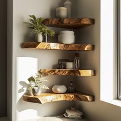 three wooden shelves in the corner of a room with plants and vases on them