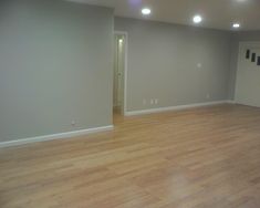 an empty living room with hard wood flooring and lights on the ceiling is lit by recessed lighting