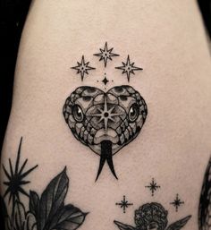 a tattoo on the back of a woman's thigh with an owl and stars