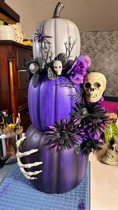 a purple pumpkin decorated with skulls and flowers