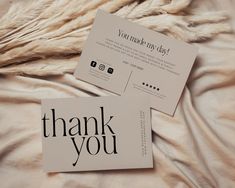 two thank you cards sitting on top of a bed next to a furnishing