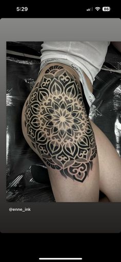 a woman's thigh with an intricate tattoo on it