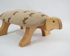 a small wooden bench with a fabric seat cover on it's back and legs