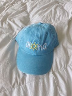 a baby blue classic baseball cap with “aloha” embroidered in yellow on the front! one size fits most, adjustable back Cute Beach Hat, Cute Hats Aesthetic, Blue Snapback Hat For Vacation, Blue Baseball Cap With Curved Brim For Vacation, Blue Curved Brim Baseball Cap For Vacation, Light Blue Snapback Hat For Summer, Casual Adjustable Yellow Fitted Hat, Casual Yellow Adjustable Fitted Hat, Blue Dad Hat One Size For Summer