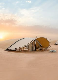 two tents set up in the desert at sunset