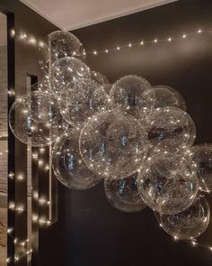 a bunch of clear balls hanging from the ceiling in a room with lights on it