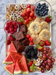 a platter filled with fruit, cookies and pastries