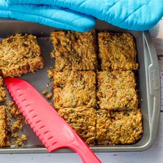 a tray filled with food next to a red spatula