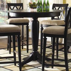 a dining room table with four chairs and bottles on it