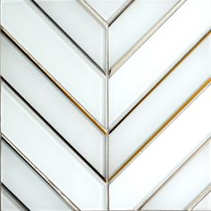 a close up view of some white and gold tiles