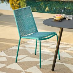 a blue chair sitting next to a table on top of a rug