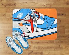 a pair of blue sneakers sitting on top of a wooden floor next to an orange rug