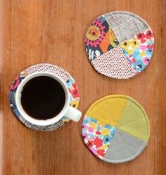 two coasters with different designs on them and a cup of coffee in front of them