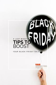 a person holding a black balloon with the words black friday written on it in white