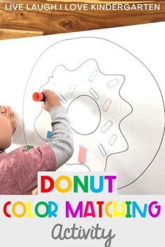 a young child is drawing on a white board with the words donut color matching activity