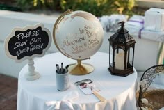 a white table topped with a globe and two small chalkboards on top of it