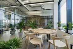 a table and chairs in a room with plants on the window sill next to it