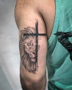 a lion with a cross tattoo on his arm