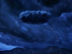 a kite flying in the sky at night with clouds and mountains behind it, under a blue cloudy sky filled with stars