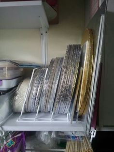 several stacks of silver and gold plates stacked on top of each other in a kitchen