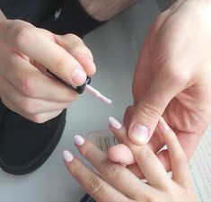 two people are doing manicures on their nails while one person is holding an electronic device