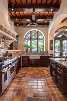 a large kitchen with an arched ceiling and tile flooring is pictured in this image