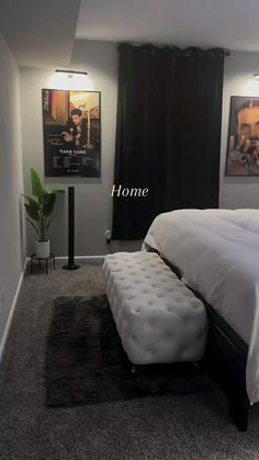 a white bed sitting in a bedroom next to two pictures on the wall above it