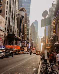 a city street filled with lots of tall buildings and people walking on the side of it