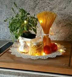 pasta, tomatoes and garlic on a plate next to a potted plant with lights