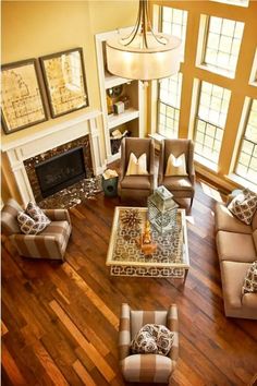 a living room with couches, chairs and a fire place in the middle of it