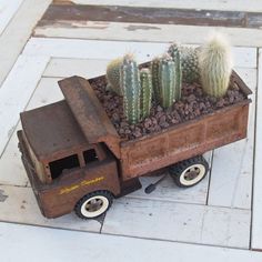 an old toy truck with cactus in it