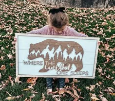 "The perfect addition to a child's bedroom or nursery, this whimsical sign features a nighttime mountain view framed within the shiloette of a bear. The words \"Where The Wild One Sleeps\" run through the image. Walnut and Birch woods lend a simplistic, natural design. Also available in a plural sign - Where the Wild Ones Sleep. Perfect for a twin nursery or baby shower gift! This framed wood sign is laser cut from natural walnut and birch woods, then hand painted in my studio in the Hudson Vall Nursery Ideas Wilderness, Mountain Wilderness Nursery, Forest Adventure Nursery, Forest Theme Nursery Boy, Woods Nursery Theme, Mountain Nursery Decor, Mountain Baby Nursery, Alaska Nursery, Outdoorsy Nursery Boy Rooms