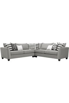 a gray sectional couch with pillows on it's back and side facing each other